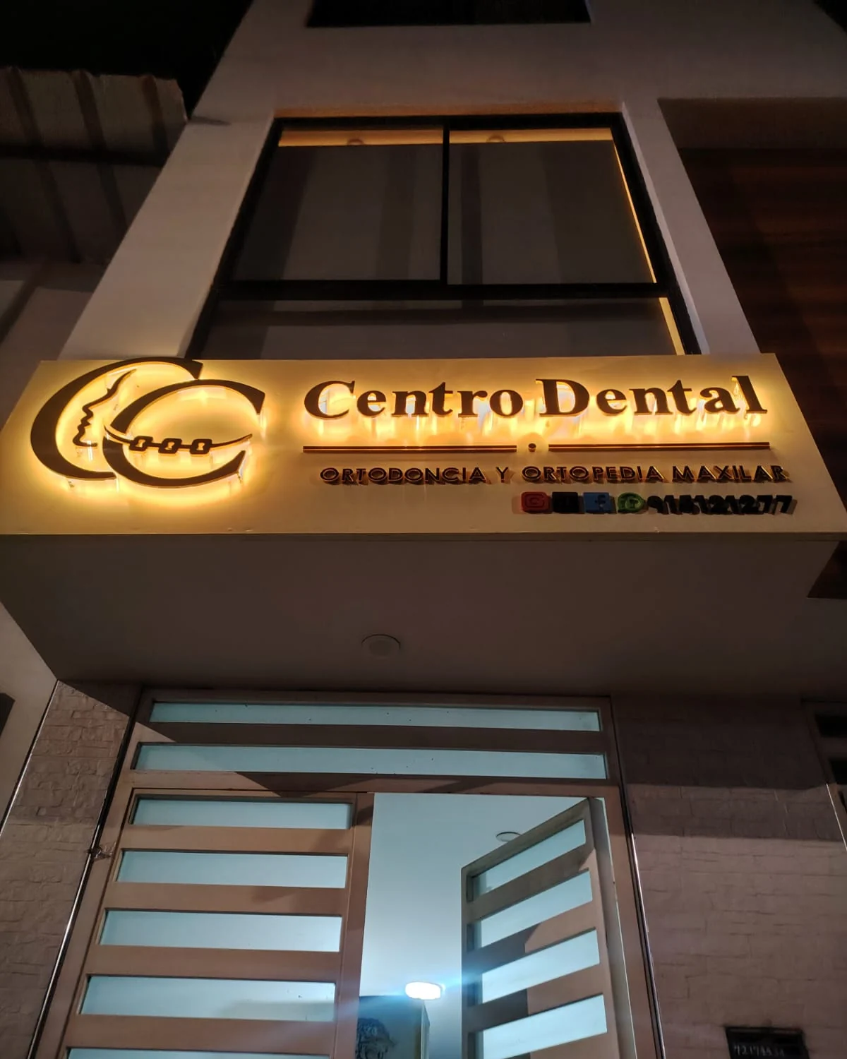Fachada nocturna del Centro Dental, con el letrero iluminado de Ortodoncia y Ortopedia Maxilar
